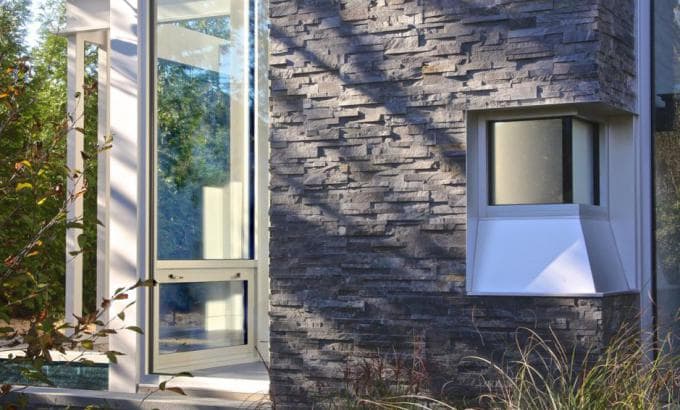 Norstone Charcoal Rock Panels used as stone siding on a residential exterior in the Hamptons